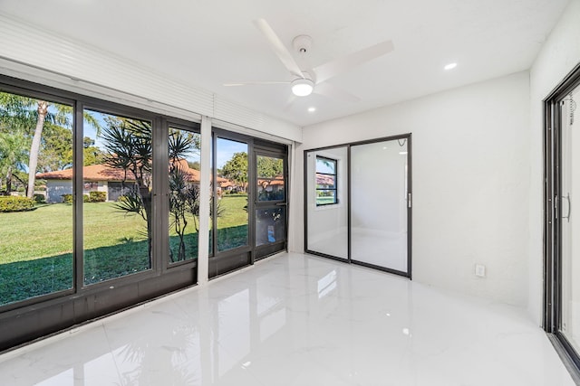 spare room featuring ceiling fan and a wealth of natural light