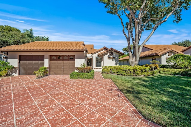 mediterranean / spanish-style home with a garage and a front lawn