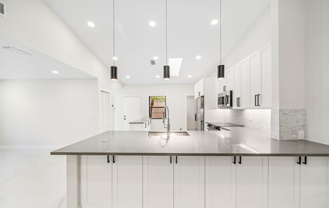 kitchen featuring white cabinetry, sink, stainless steel appliances, kitchen peninsula, and decorative light fixtures