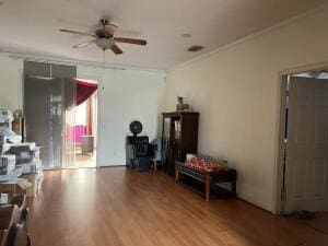 interior space featuring ceiling fan, ornamental molding, and light hardwood / wood-style flooring