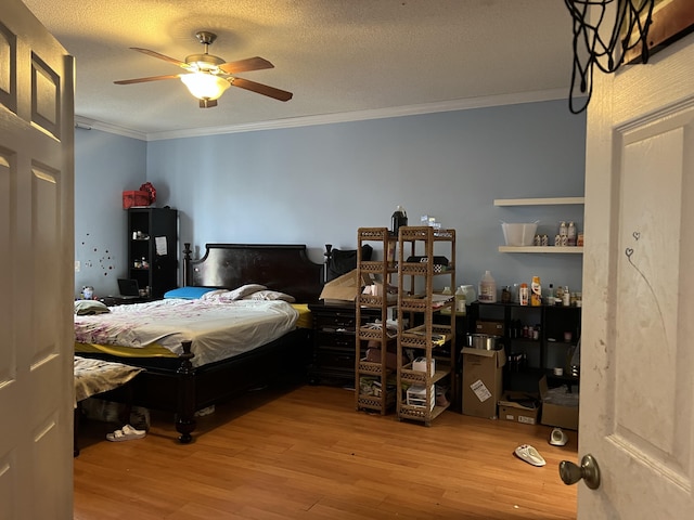 bedroom featuring a textured ceiling, light hardwood / wood-style floors, ceiling fan, and ornamental molding