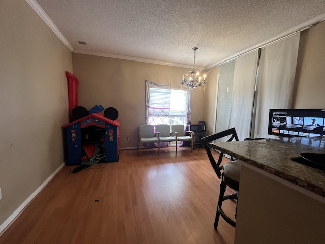 dining space with hardwood / wood-style flooring, a notable chandelier, ornamental molding, and a textured ceiling