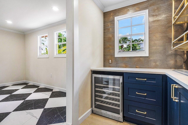 bar featuring ornamental molding, blue cabinets, and beverage cooler