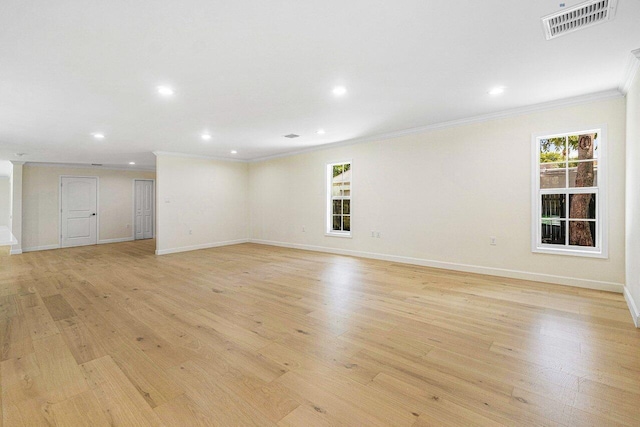 spare room featuring crown molding and light hardwood / wood-style flooring