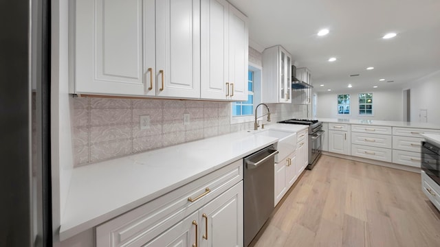 kitchen with tasteful backsplash, white cabinets, and appliances with stainless steel finishes