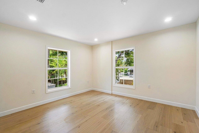 spare room featuring plenty of natural light and light hardwood / wood-style flooring