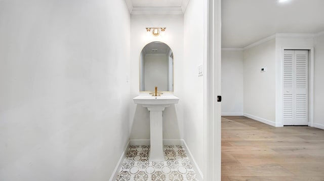 corridor with light hardwood / wood-style flooring and ornamental molding