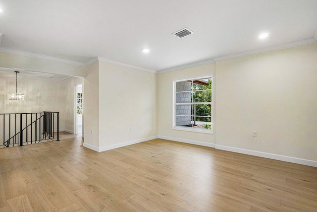 unfurnished room featuring crown molding, light hardwood / wood-style flooring, and a notable chandelier