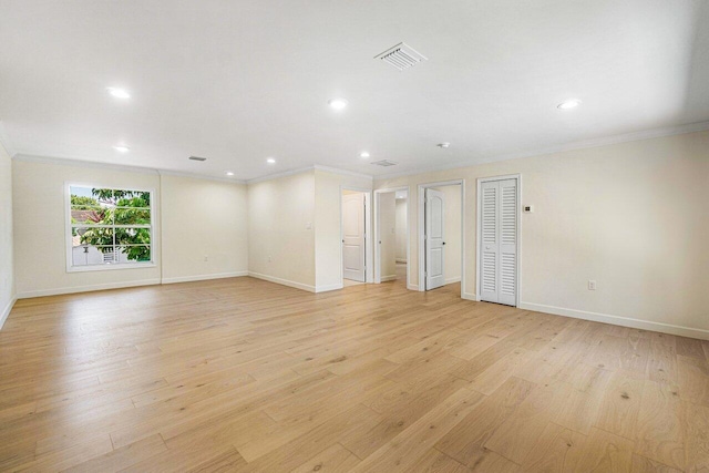 spare room featuring light hardwood / wood-style flooring and crown molding