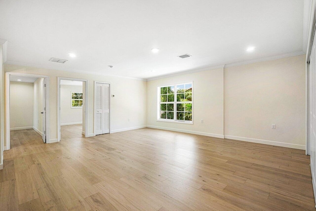 unfurnished room with light wood-type flooring and crown molding