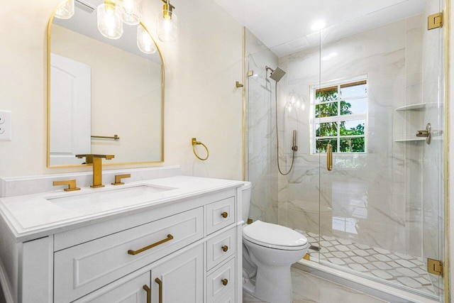 bathroom with vanity, toilet, and a shower with door