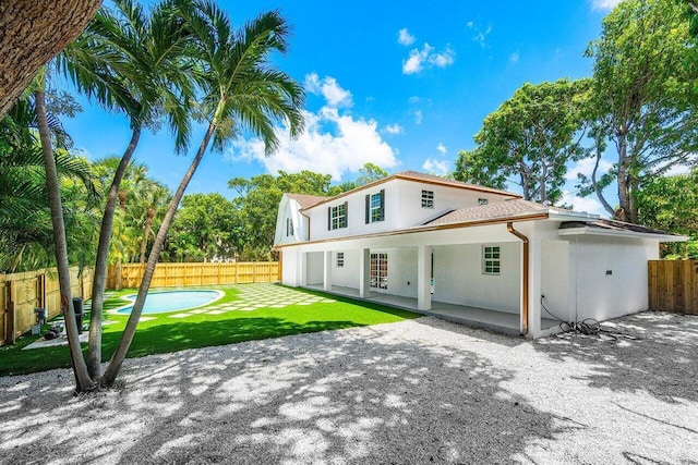 rear view of house featuring a lawn and a patio