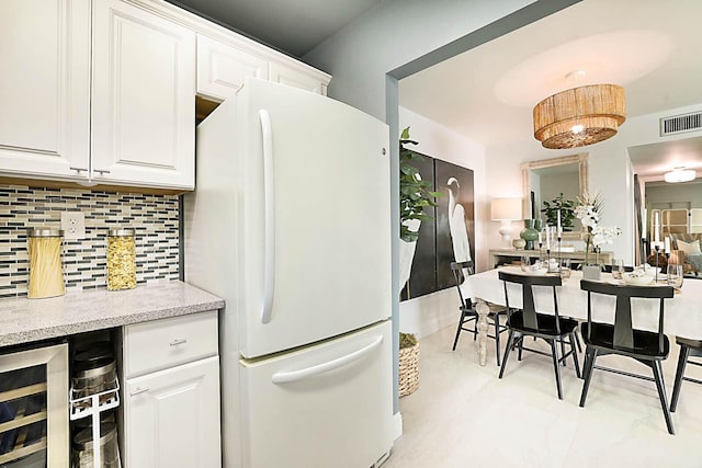 kitchen featuring tasteful backsplash, wine cooler, light tile patterned flooring, white refrigerator, and white cabinets