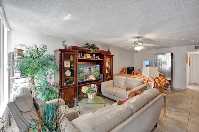 tiled living room with a textured ceiling and ceiling fan