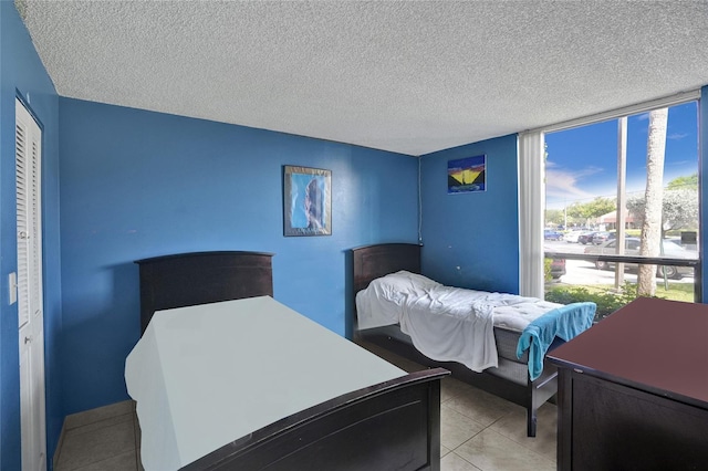 bedroom featuring a textured ceiling and light tile patterned flooring