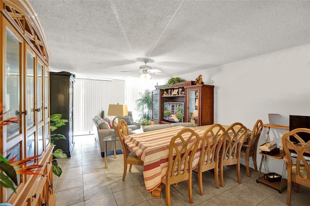 tiled dining room featuring ceiling fan and a textured ceiling