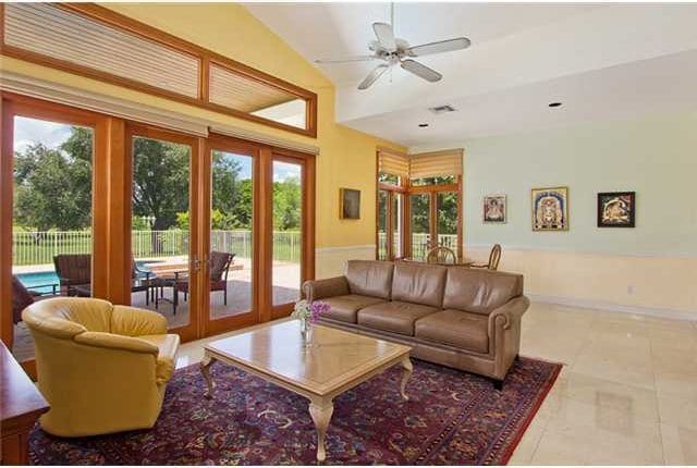 tiled living room featuring french doors, vaulted ceiling, plenty of natural light, and ceiling fan