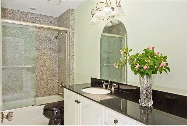 bathroom featuring vanity and enclosed tub / shower combo