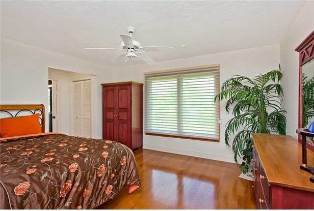 bedroom featuring hardwood / wood-style flooring, ceiling fan, and a closet