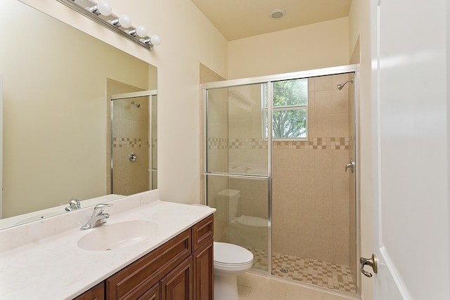 bathroom featuring tile patterned floors, vanity, toilet, and walk in shower