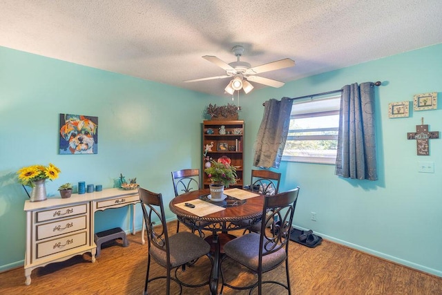 dining space with a textured ceiling, light wood-type flooring, and ceiling fan