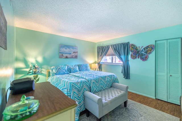 bedroom with a closet, hardwood / wood-style floors, and a textured ceiling