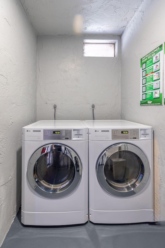 washroom with a textured ceiling and washing machine and clothes dryer