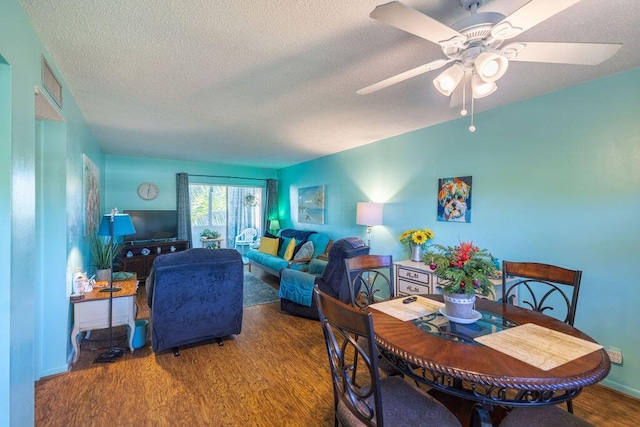 dining area featuring ceiling fan, dark hardwood / wood-style flooring, and a textured ceiling