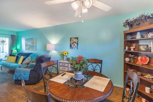 dining room with a textured ceiling, hardwood / wood-style flooring, and ceiling fan