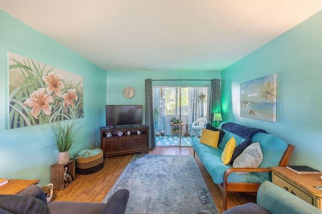 living room featuring wood-type flooring and a textured ceiling