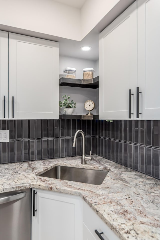 kitchen featuring white cabinetry, stainless steel dishwasher, and sink