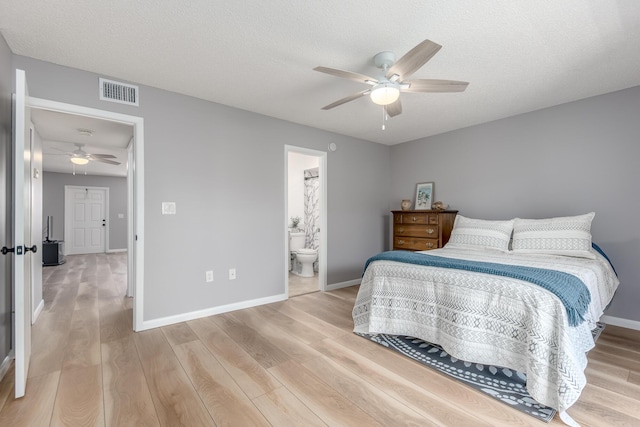 bedroom featuring ceiling fan, wood-type flooring, a textured ceiling, and connected bathroom