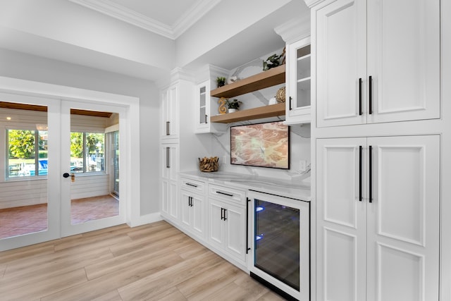 bar with white cabinets, crown molding, wine cooler, and light hardwood / wood-style flooring