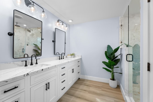 bathroom featuring wood-type flooring, vanity, and a shower with shower door