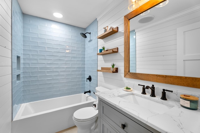 full bathroom featuring tiled shower / bath combo, vanity, and toilet