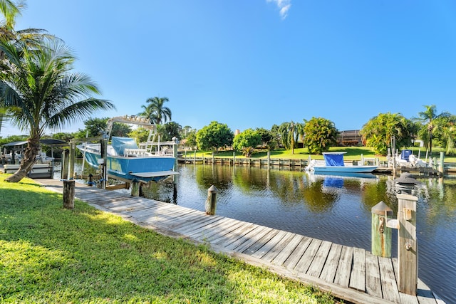 view of dock with a water view and a yard