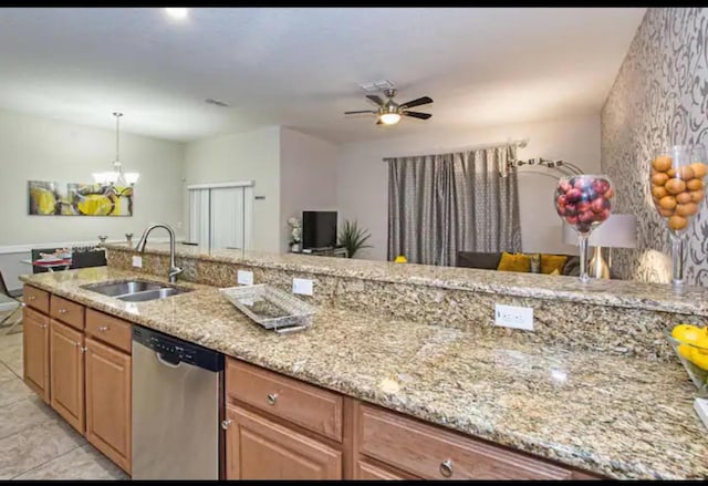 kitchen with ceiling fan with notable chandelier, sink, stainless steel dishwasher, light stone countertops, and decorative light fixtures