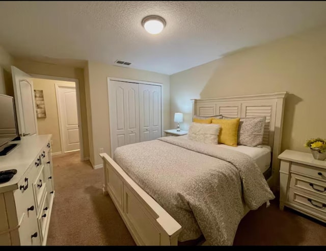 carpeted bedroom with a closet and a textured ceiling