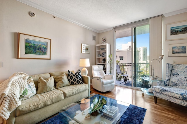 living room featuring wood-type flooring, a textured ceiling, and crown molding