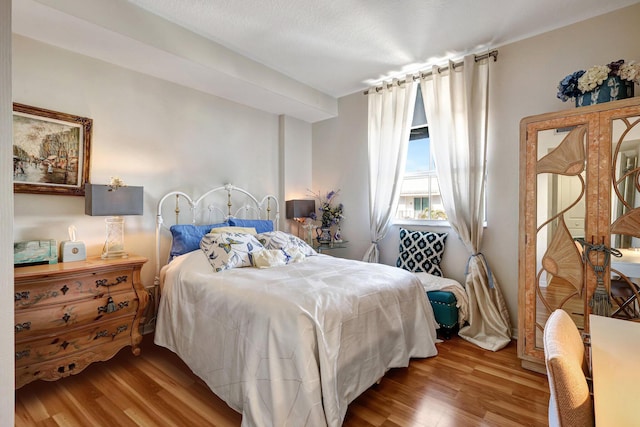 bedroom featuring a textured ceiling and light hardwood / wood-style flooring