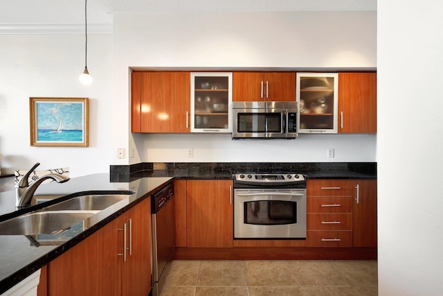 kitchen featuring decorative light fixtures, stainless steel appliances, dark stone countertops, and sink