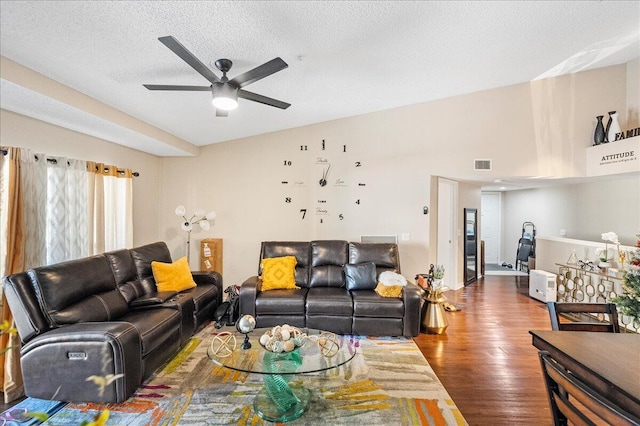 living room featuring ceiling fan, hardwood / wood-style floors, and a textured ceiling