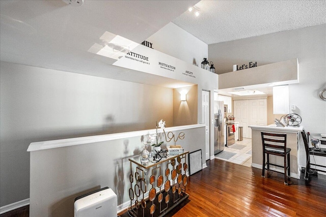 hall with wood-type flooring and a textured ceiling