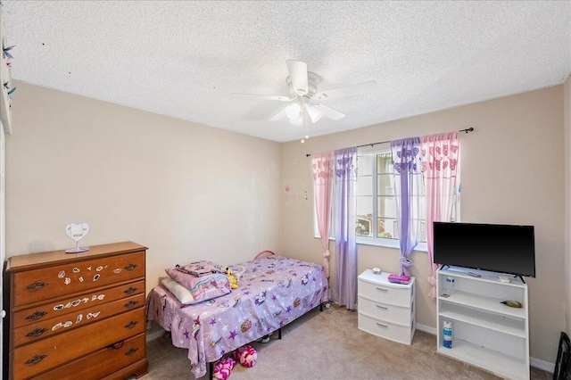 carpeted bedroom with ceiling fan and a textured ceiling