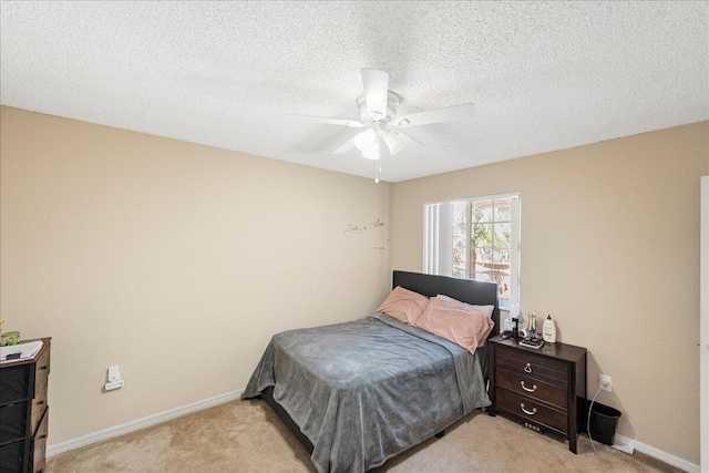 carpeted bedroom with ceiling fan and a textured ceiling