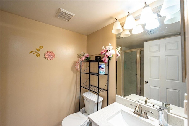 bathroom with vanity, toilet, and a shower with shower door