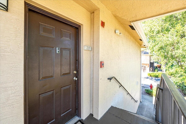 view of exterior entry with a balcony