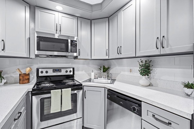 kitchen featuring decorative backsplash, appliances with stainless steel finishes, and sink