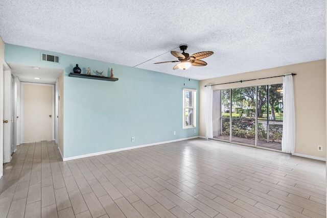 spare room with ceiling fan, light hardwood / wood-style floors, and a textured ceiling