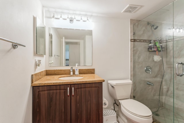 bathroom featuring vanity, toilet, and a shower with door